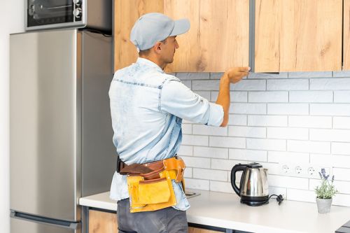 Handwerker baut Küchenschrank ein